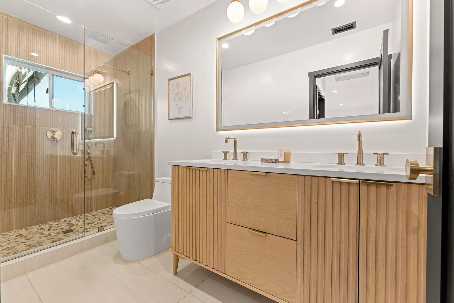 Primary bath with a fluted oak double vanity, brass fixtures, and a glass-enclosed walk-in shower, DHRH Campanil renovation