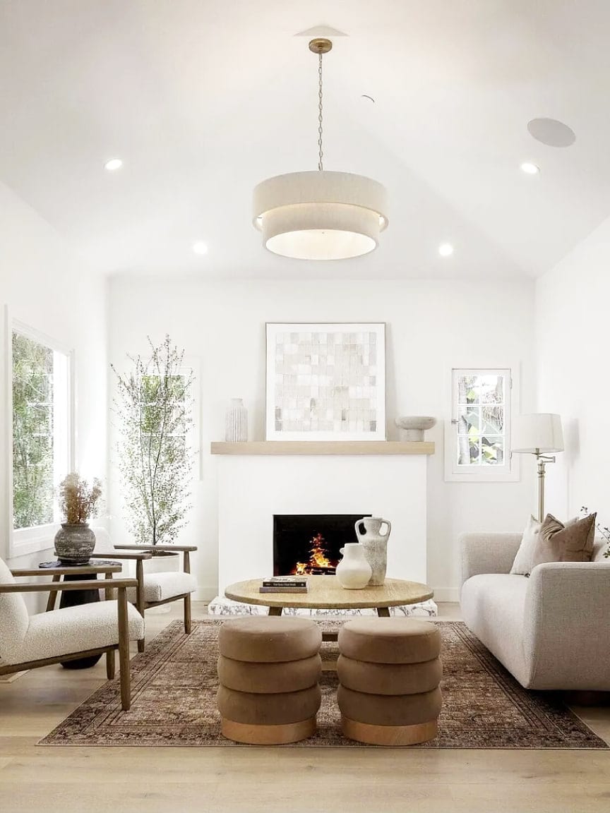 Living room with a drum pendant, a lit fireplace, and a layered rug, DHRH Montecito renovation