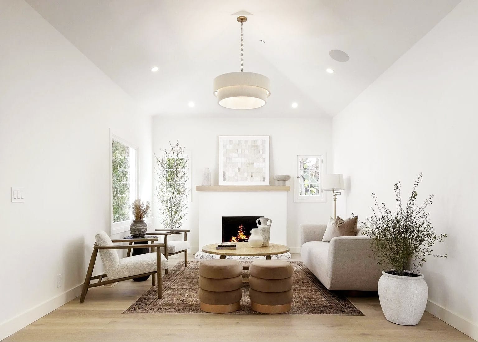 Vaulted living room with a lit fireplace and white oak floors, DHRH Montecito renovation