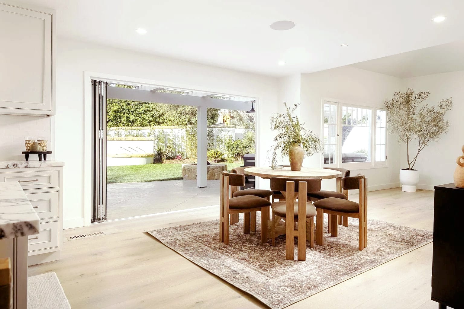 Dining room opening to the garden through folding glass doors, DHRH Montecito renovation