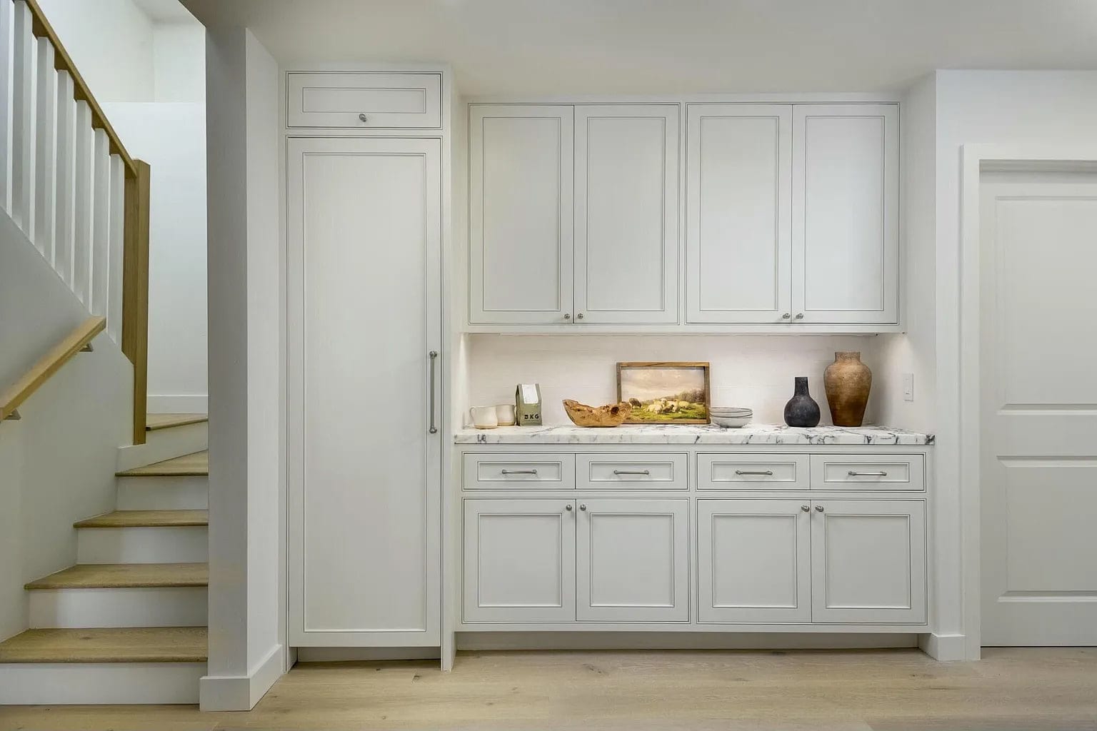 White oak stair beside a wall of cabinetry with a marble counter, DHRH Montecito renovation