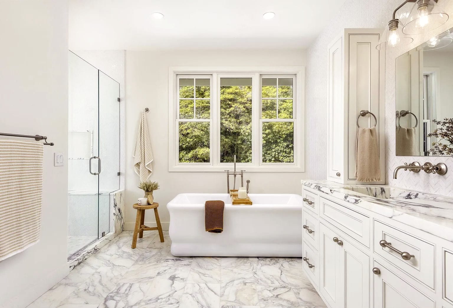 Primary bath with a freestanding tub, marble floors, and a glass shower, DHRH Montecito renovation