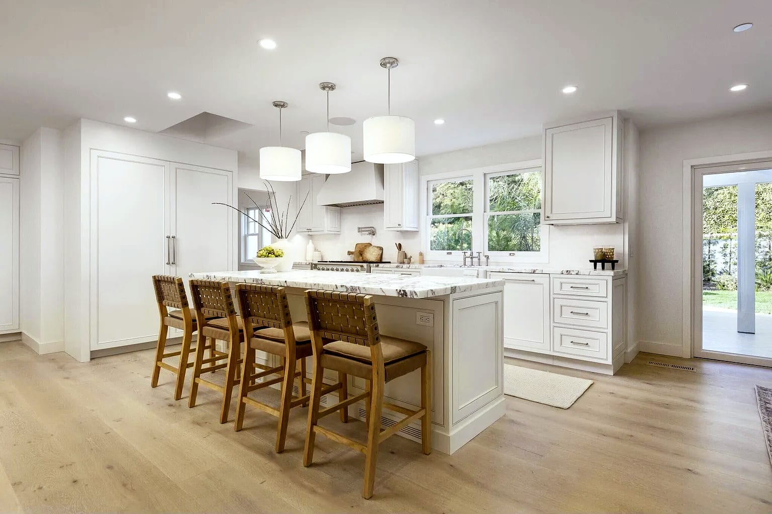 Marble island kitchen with drum pendants and glass doors to the garden, DHRH Montecito renovation
