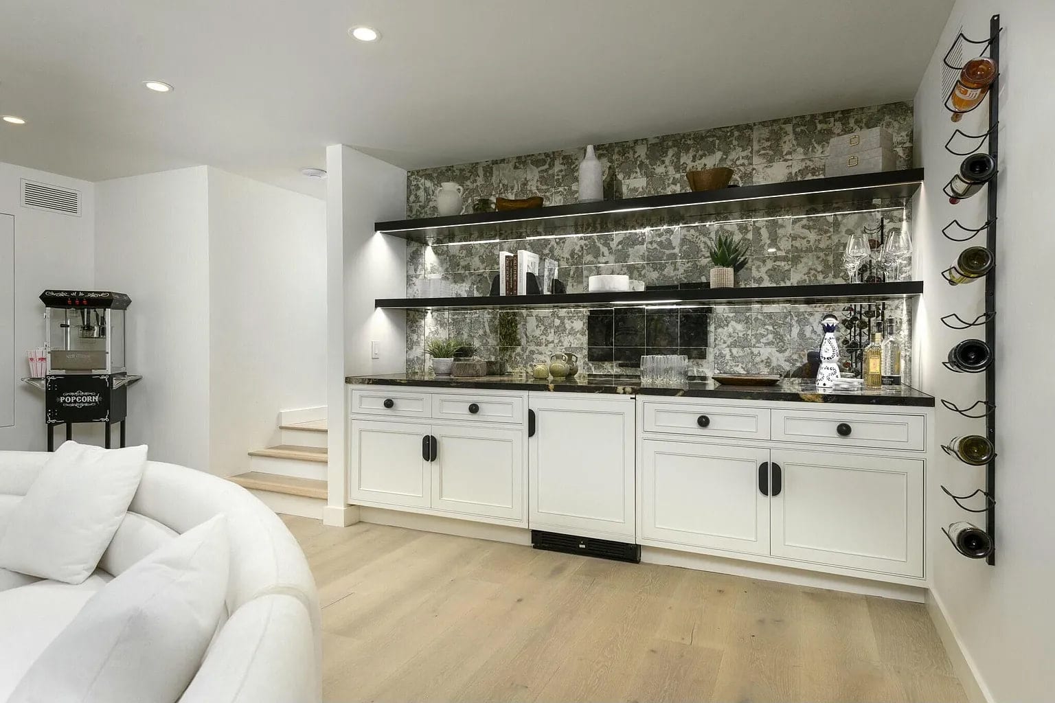 Lounge bar with mirrored tile, floating black shelves, and a wine rack, DHRH Montecito renovation